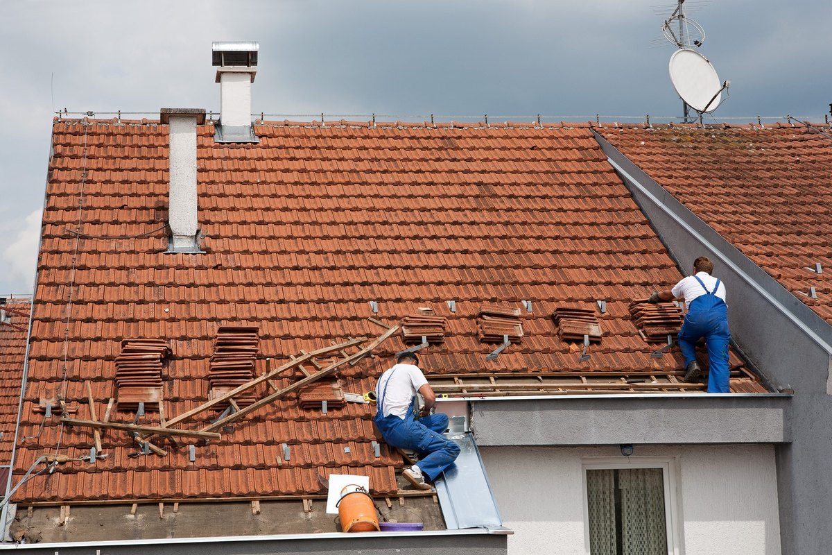 Professional roofers working on a UK house roof